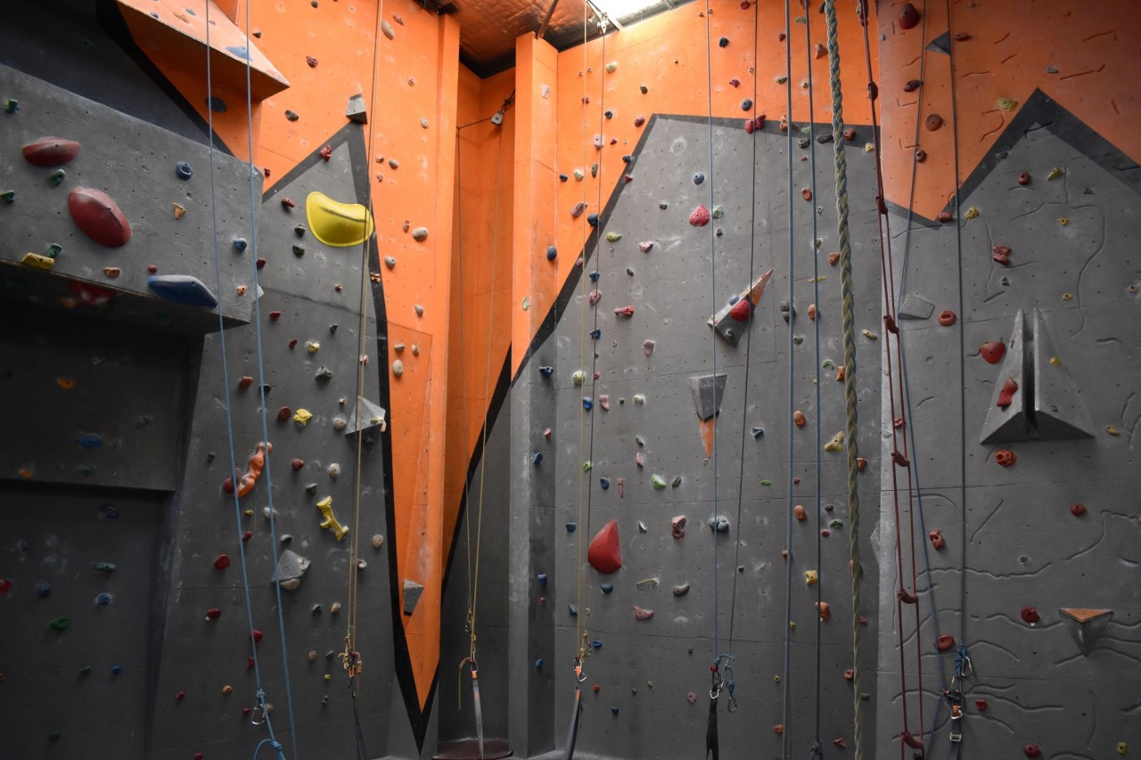 A corner of the Mitchell gym, featuring climbing walls and a chimney with no holds.
