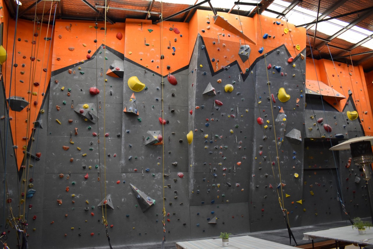 The next section of climbing walls, designed with varying degrees of incline. In addition to holds, we also affix features to the walls, which are changed regularly to switch things up for our regular climbers. Quick draws placed on the wall indicate places where qualified climbers can lead climb.