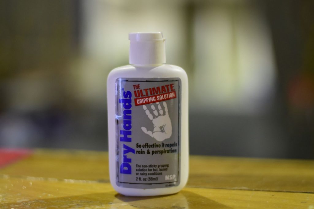 A flip-top bottle of dry hands non-sticky gripping solution.