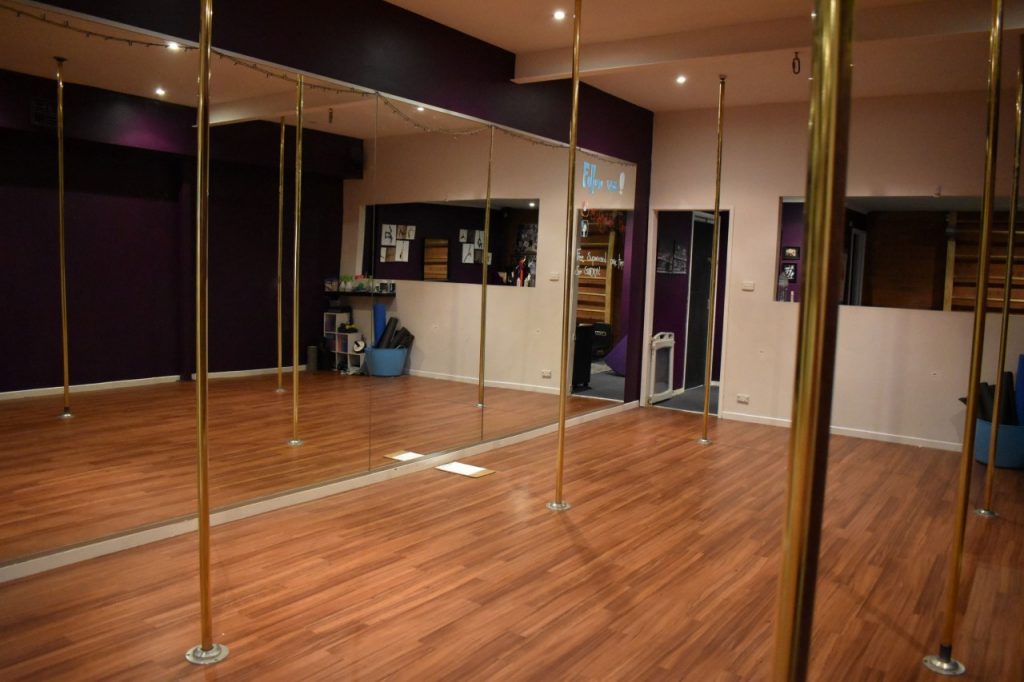 Walls covered in mirrors allow pole dancers to examine their own movements.