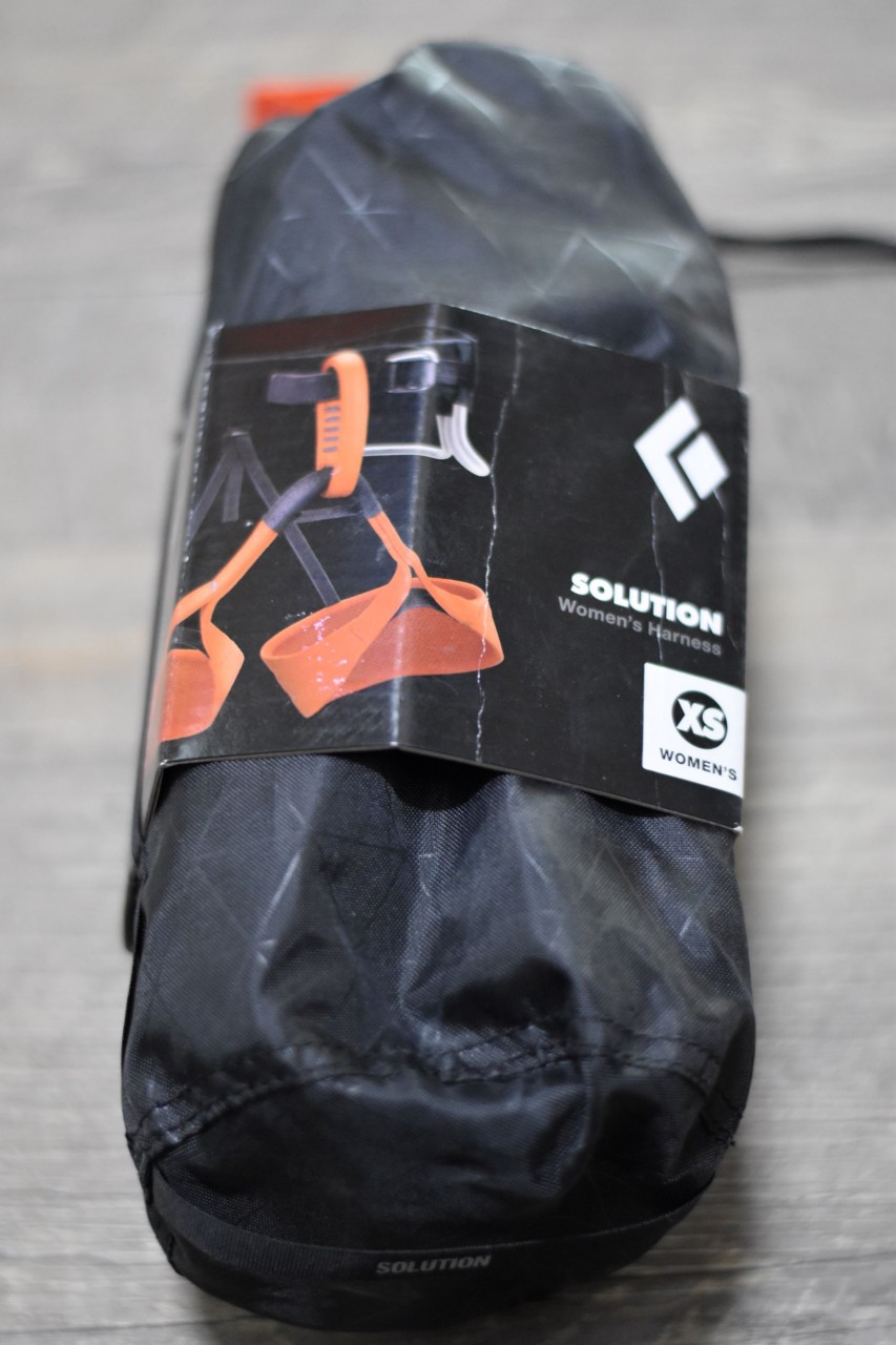 A Black Diamond women's XS Solution harness in its bag