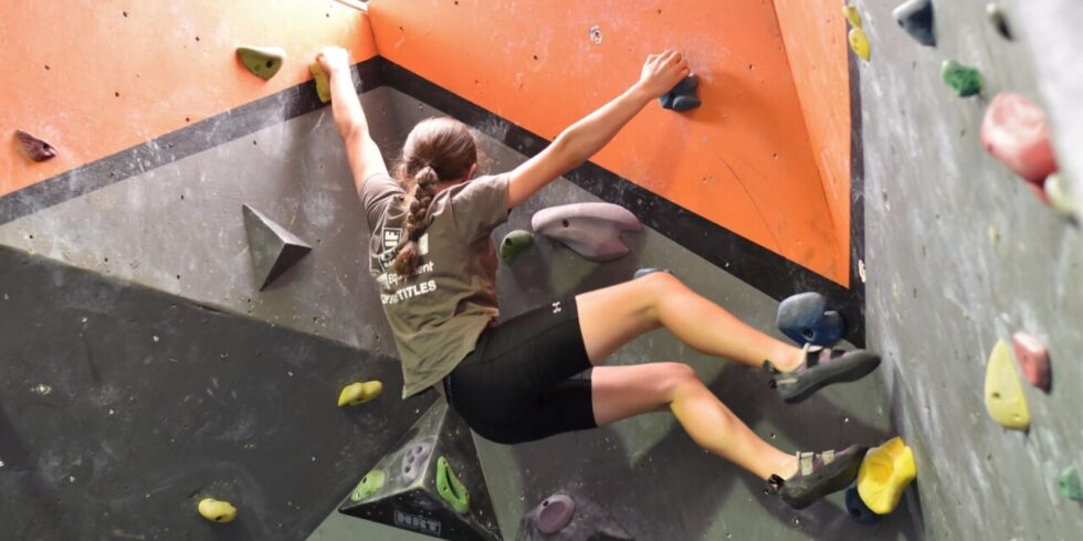 A photo of a girl in our elite Rock Squad bouldering at Mitchell.